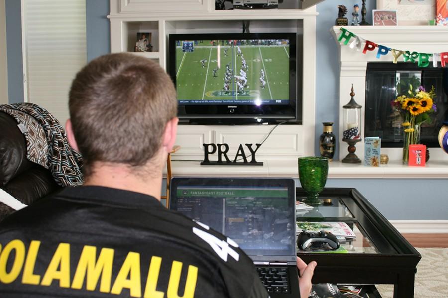 Senior Ethan Crocker closely monitors his fantasy football team while watching the San Diego Chargers take on the Seattle Seahawks.