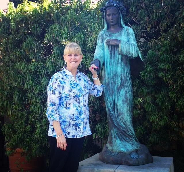 Hormuth stands next to a statue of Mother Mary.