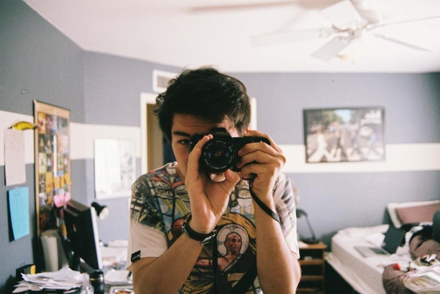 Reyes takes a picture of himself in his room through the view of a mirror.