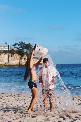 Chill at the beach - Senior Andrea Laliena dumps a bucket of ice water on senior Adam Campbell.