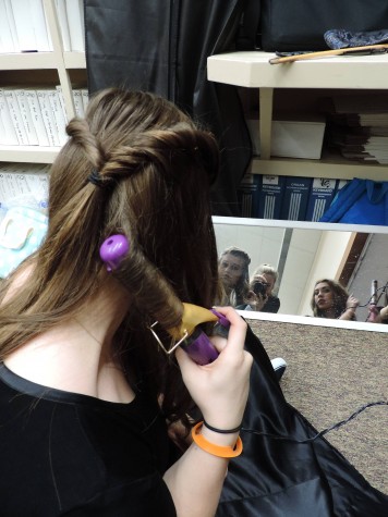Dolled up - Senior Katie Stanton perfects her hair for the dress rehearsal.