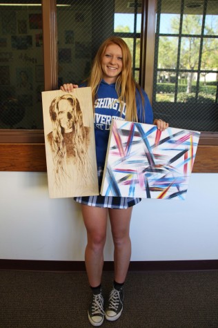 Varsity artist - Senior Corrina Thompson hold up two of her finished projects.