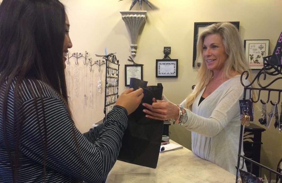 Fashion fighter - Doni Orsini, owner of Olivias Closet Boutique, attends to her customers recent purchase.