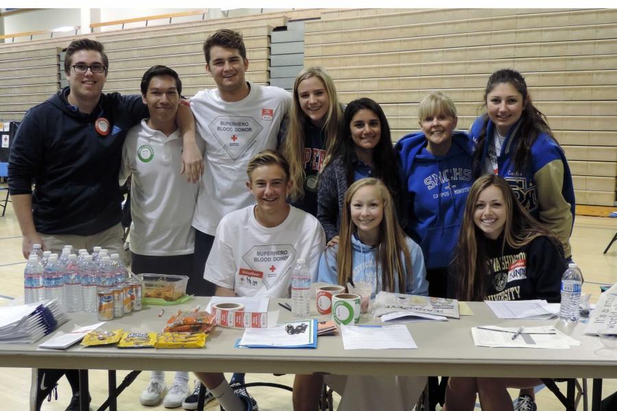 Nancy+Hormuth+and+students+who+were+present+at+the+blood+drive+smile+as+they+check+other+donors+in.+