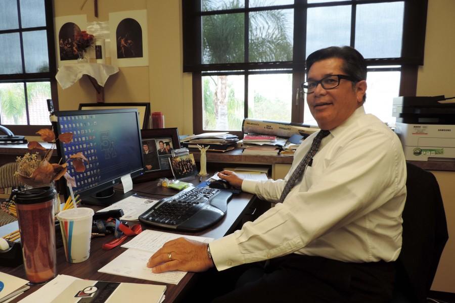 Faith and family - George Cou keeps a statue of an angel and pictures of his family at his desk at school.​