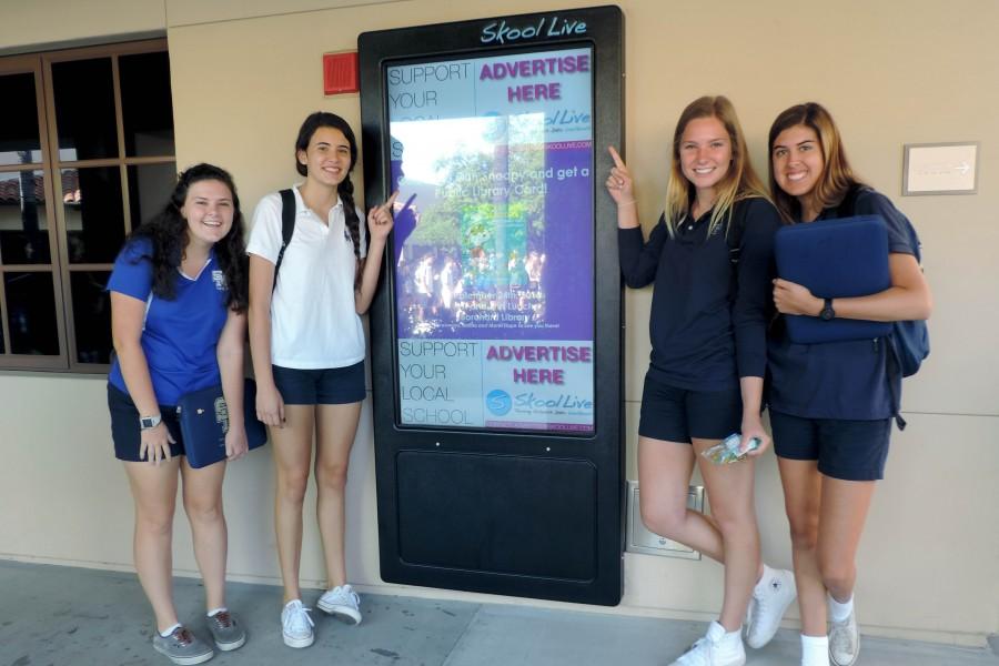 Seniors Erin McNally, Abby Tuerk, Lillie Lustig and Alexis ORourke stand next to the SkoolLive kiosk on the S building.