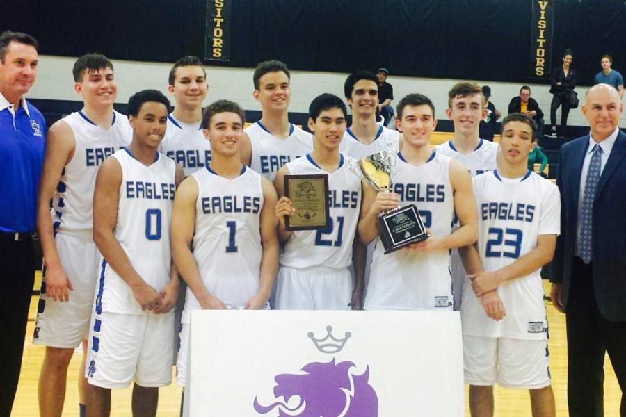 The boys basketball team holds up the championship trophy after winning the four-day Christian Cup tournament.