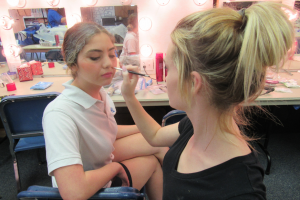 Make-up and hair designer junior Faith Quigley (right) brings senior Lara Adra's (left) character to life through make-up.