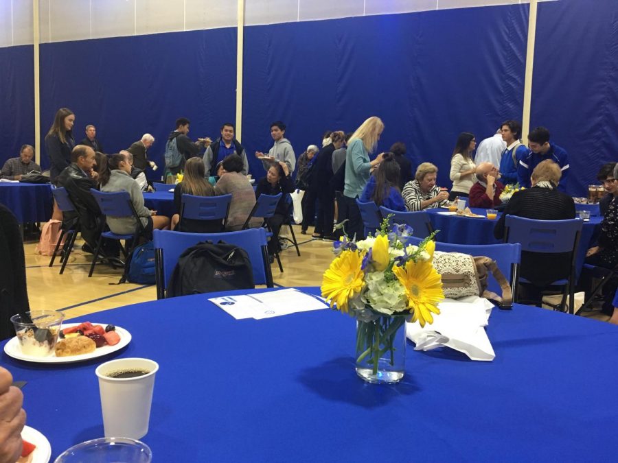 Students and their grandparents enjoy a tasty meal in the school gym during their tour of the school. 