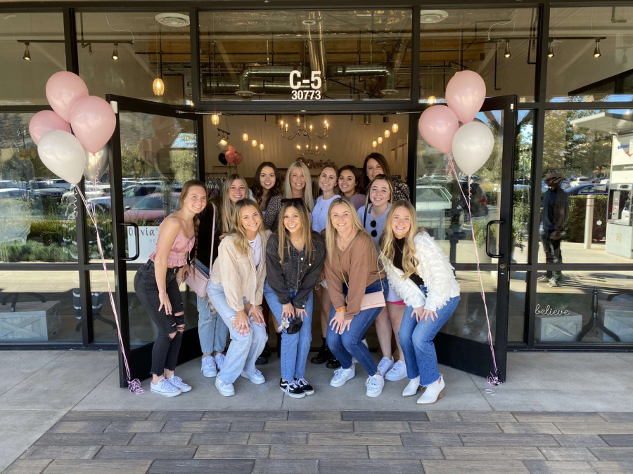 Doni Orsini and her daughter Olivia pose in front of their new storefront with friends. This dream has been a decade in the making.